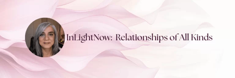 A woman with silver hair smiles warmly against a soft pink background